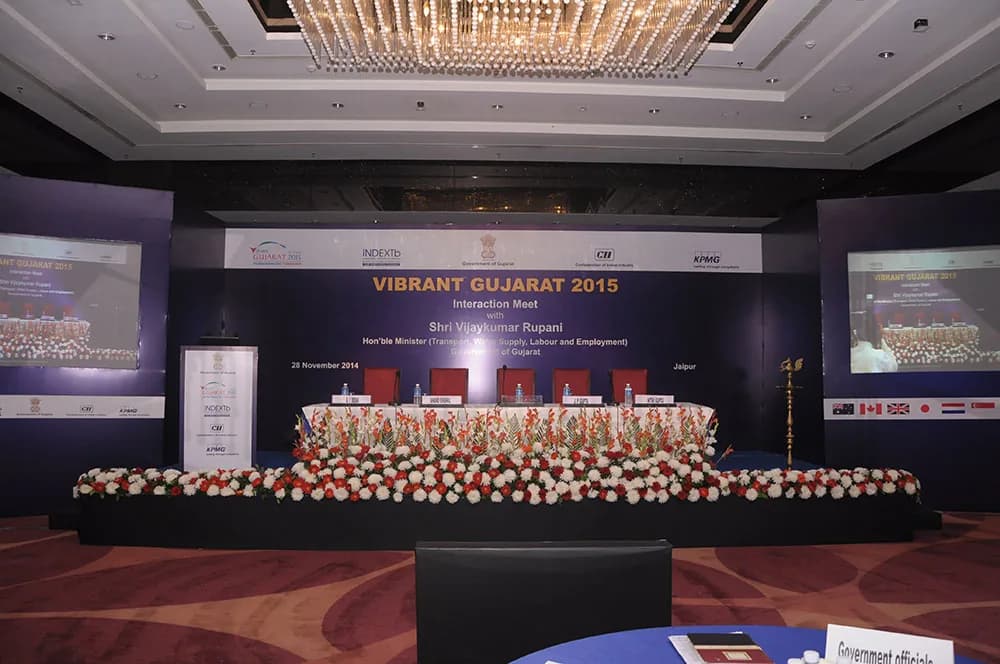 Conference stage with a floral-decorated dais, screens and national flags
