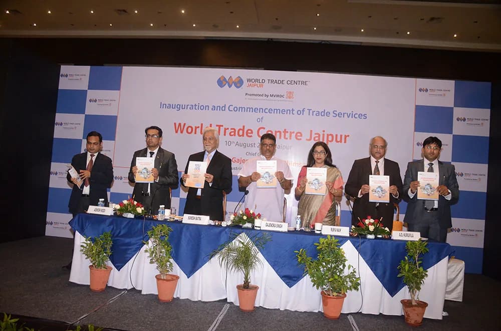 Speakers releasing a publication on a decorated dais at a trade-services inauguration